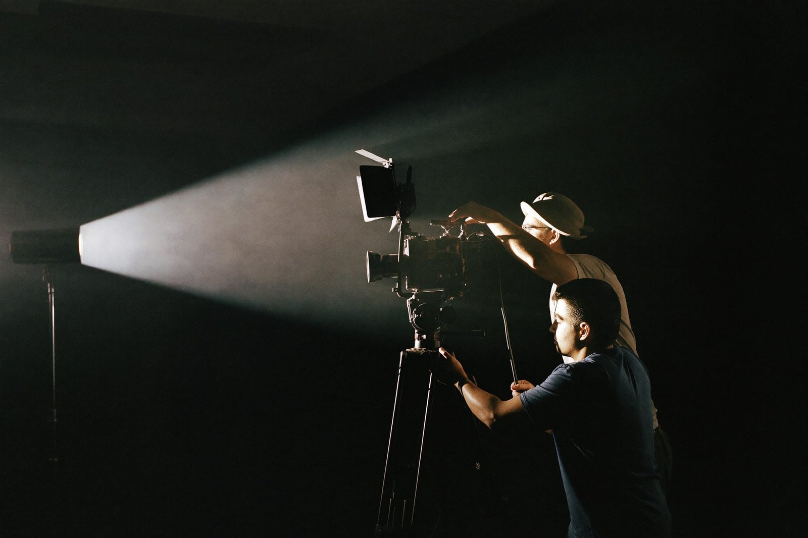 Filmcrew mit Cinema-Kamera im Studio, ein Lichtkegel schneidet durch den Raum